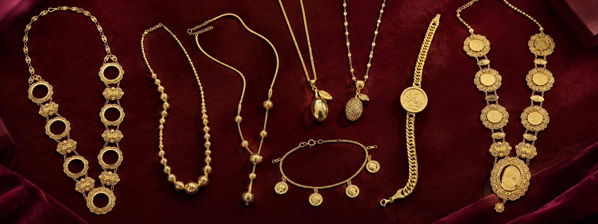 Gold necklaces, bracelets and pendants arranged on burgundy velvet